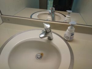 上尾市井戸木で交換前のTOTO製手洗い水栓を確認した様子
