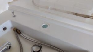 さいたま市見沼区の洗面水栓撤去後に取付穴と洗面台を確認している様子