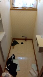 越谷市大里の1階トイレ交換工事で既設便器を撤去し排水接続部を確認している様子