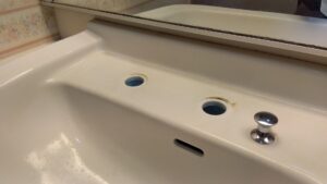 洗面水栓の吐水部とレバーを取り外した二つの取り付け穴