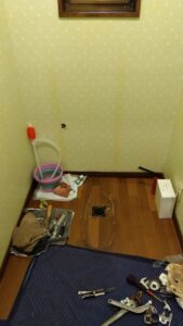 既存の便器とタンクを撤去し、床の排水口が見える状態