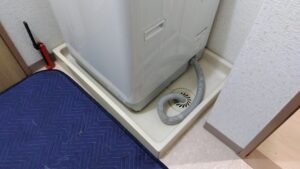 交換前の洗濯機パンと設置されている洗濯機