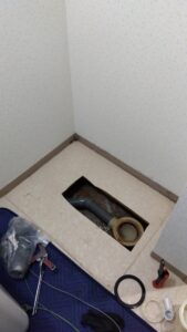 洗濯機パン撤去後の床下側の排水管と排水トラップ