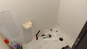 既存トイレと壁リモコンを撤去した後の室内と床排水口